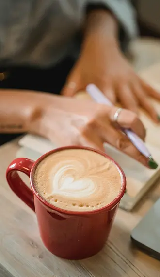 Our team sitting down with a cup of coffee, a pen and notepad